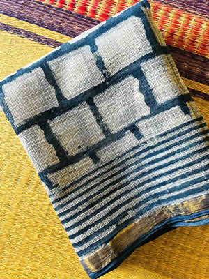Folded indigo and ivory checked fabric detail with striped edging
