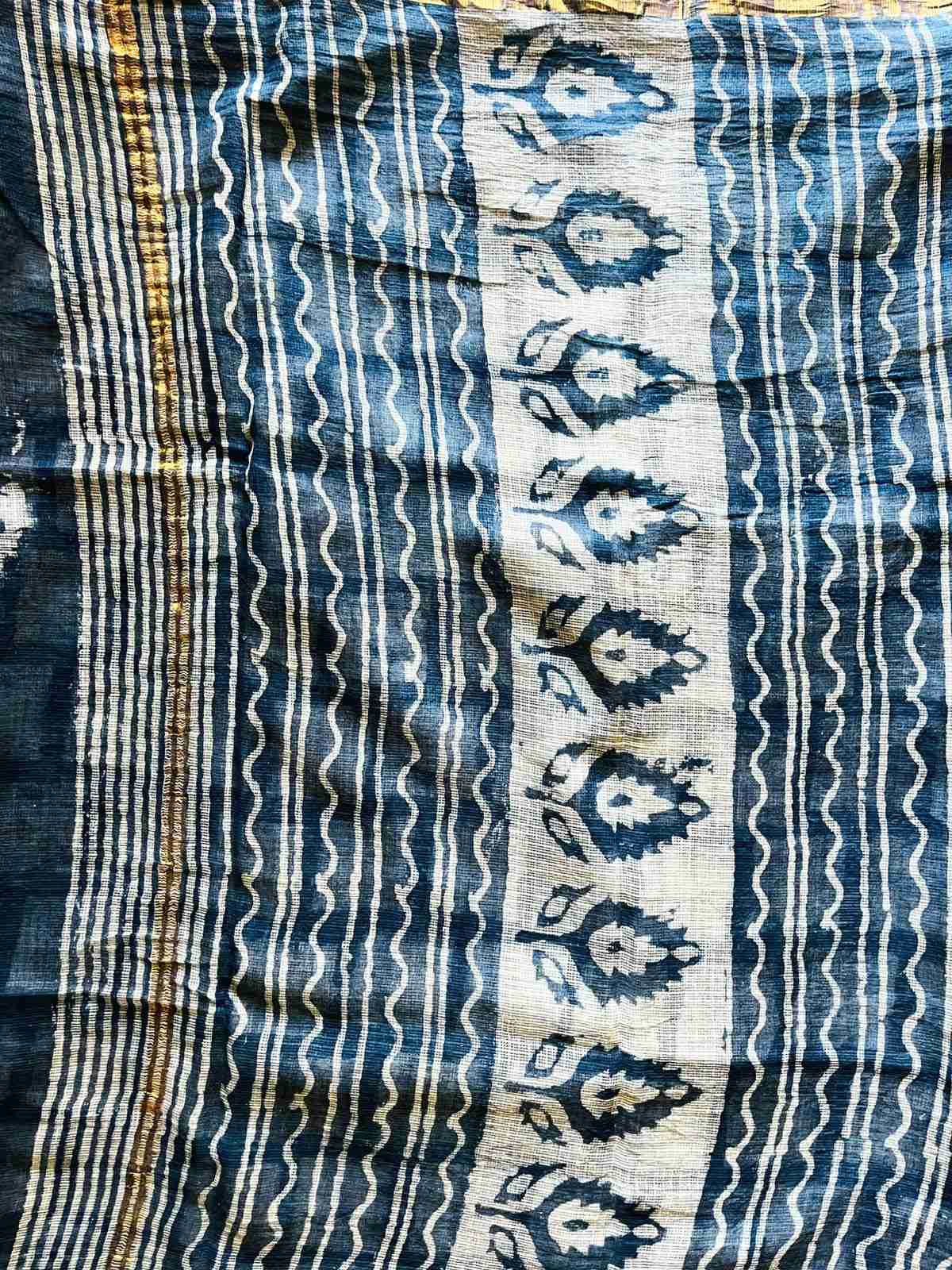 Close-up of ivory blooms and dotted trails on the indigo Mira saree
