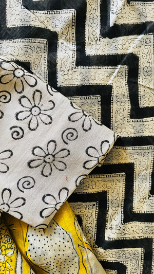 Haldi-yellow Maheswari handblocked silk cotton saree with black and ivory geometric borders and floral motifs