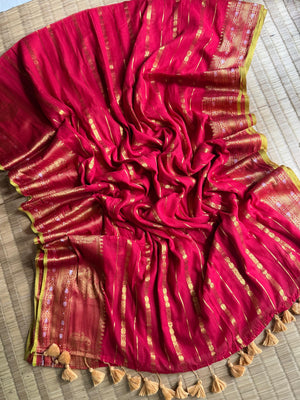 Red mul cotton saree spread out to show gold-toned accents, patterned borders, yellow-green edging and tassels