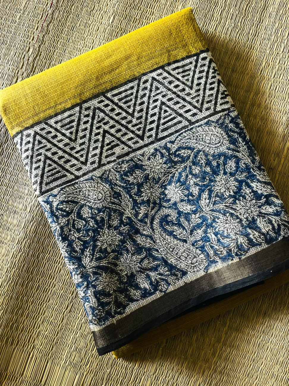 Neelambari Kota Doria Saree folded to show mustard yellow, indigo paisley florals and geometric detailing
