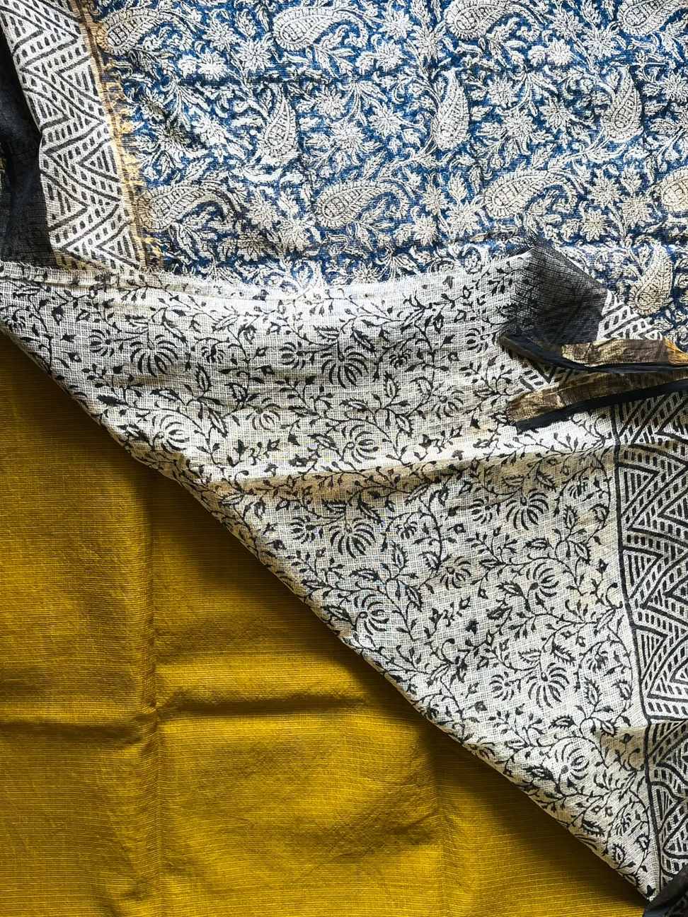 Neelambari Kota Doria Saree with mustard yellow fabric and contrasting floral and paisley patterns